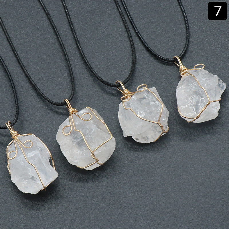 Crystal pendants on black cords against a gray background