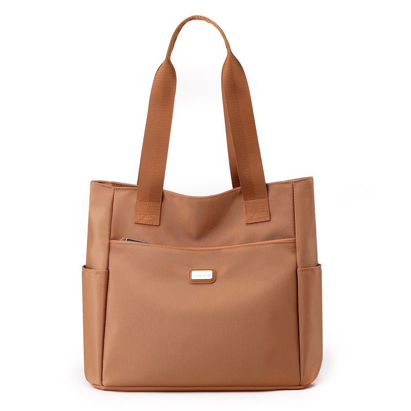 Brown tote bag with shoulder straps on a white background