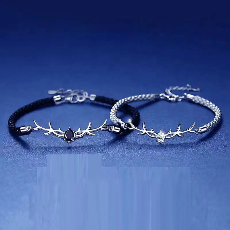 Two silver bracelets with antler designs on a blue background