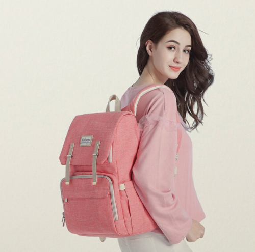 Woman wearing a pink backpack on a plain background