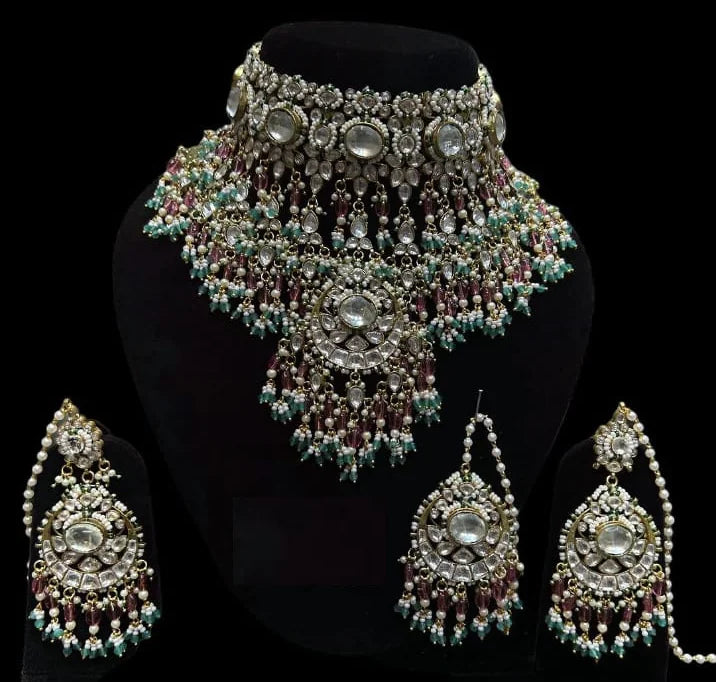 Ornate necklace and earrings set on a black background