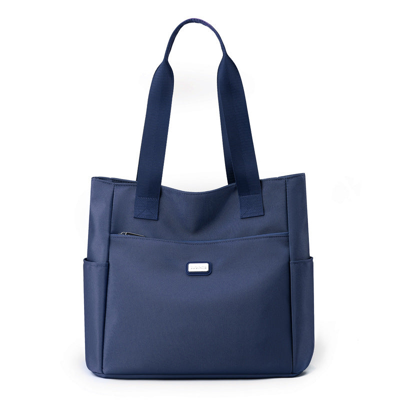 Blue tote bag with multiple pockets on a white background