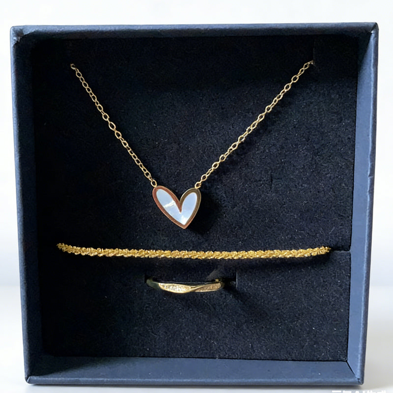 Gold necklace with heart pendant and matching bracelet in a black box