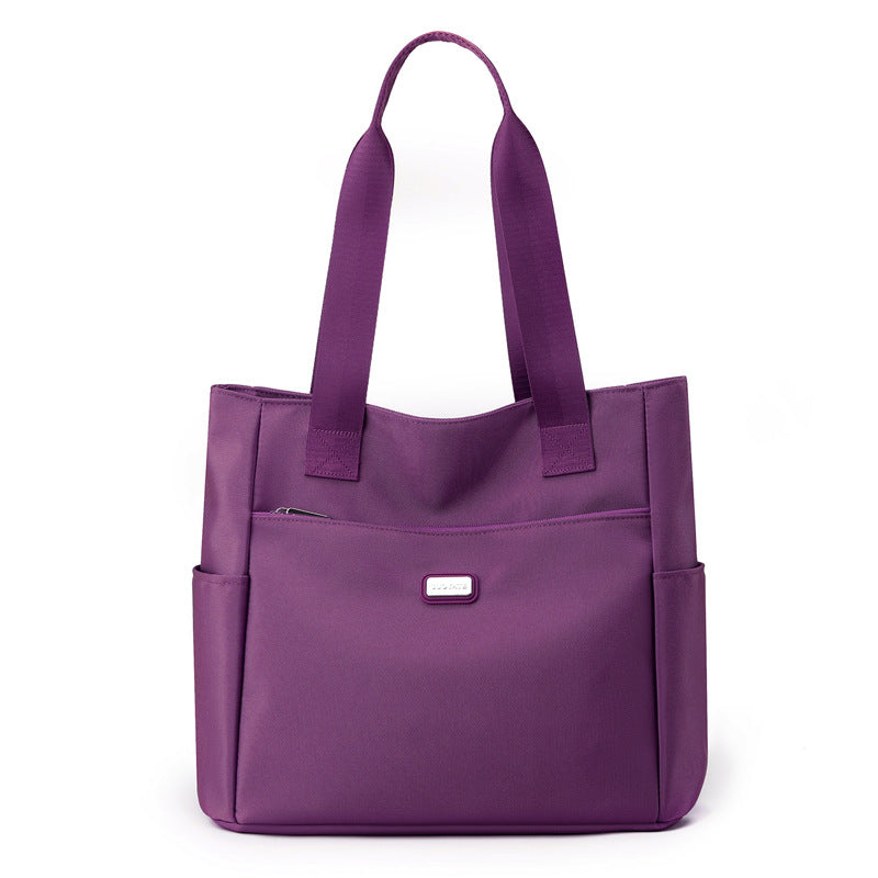 Purple tote bag with multiple pockets on a white background