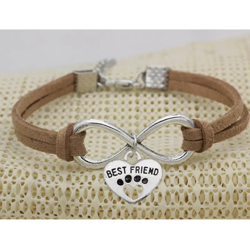 Bracelet with infinity symbol and 'Best Friend' heart charm on a textured surface