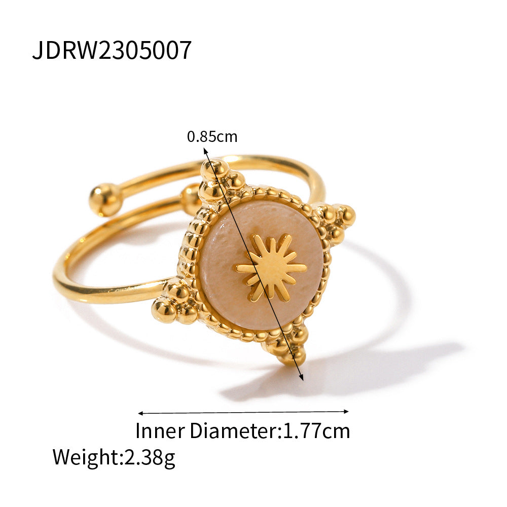 Gold ring with decorative design and measurements on a white background