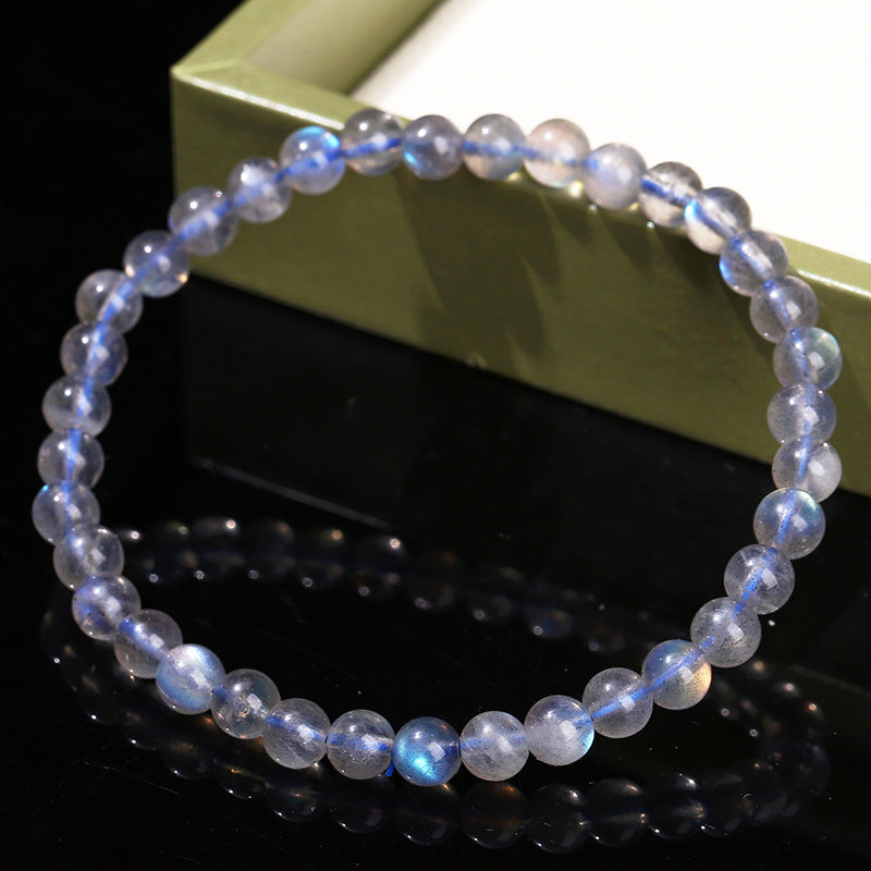 Beaded bracelet with a reflective surface on a dark background