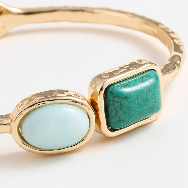 Two gold rings with turquoise stones on a white background