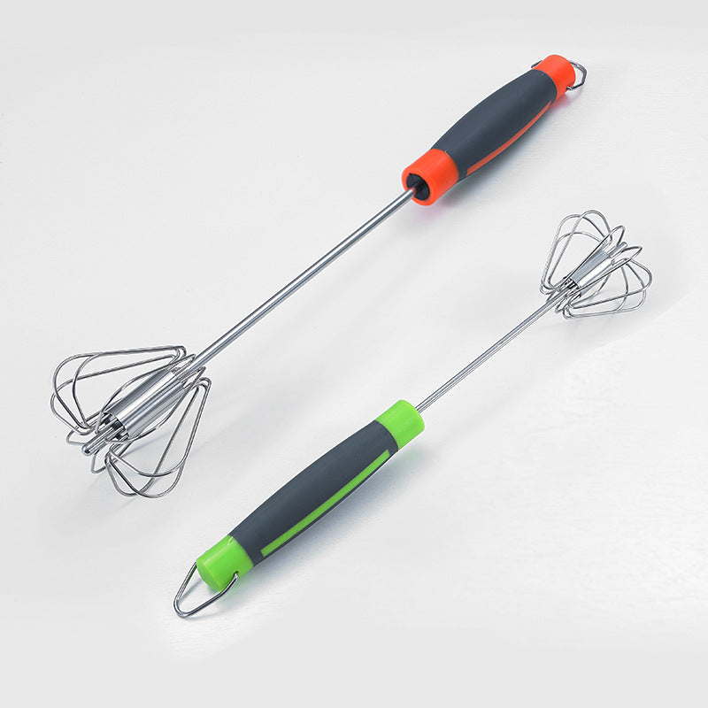 Two whisks with black and green handles on a white background