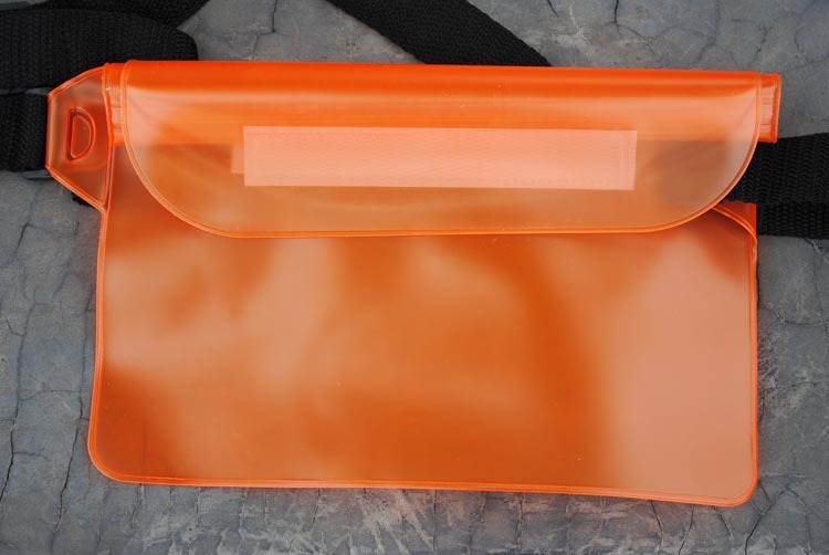 Orange transparent pouch on a textured gray surface