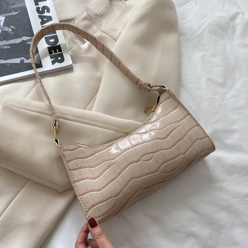 Beige handbag with textured pattern on a white surface