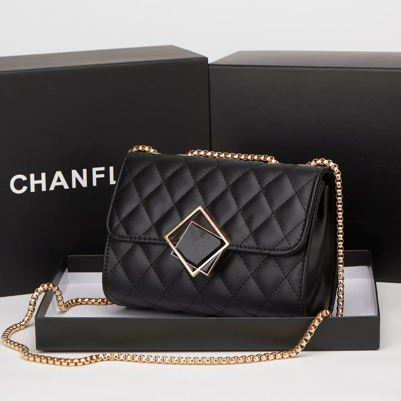 Black quilted handbag with gold chain on a Chanel branded box