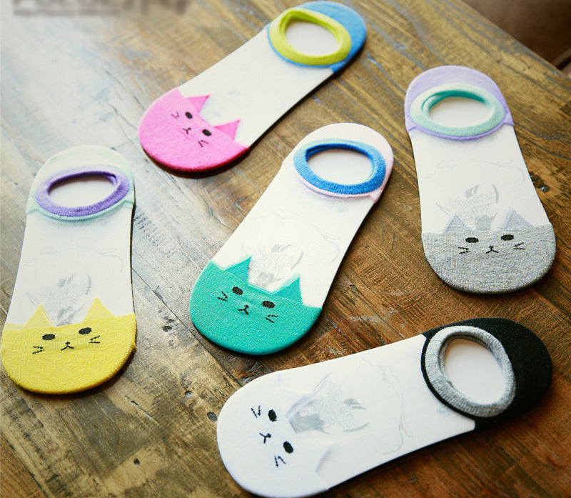 Set of colorful cat-themed socks on a wooden surface