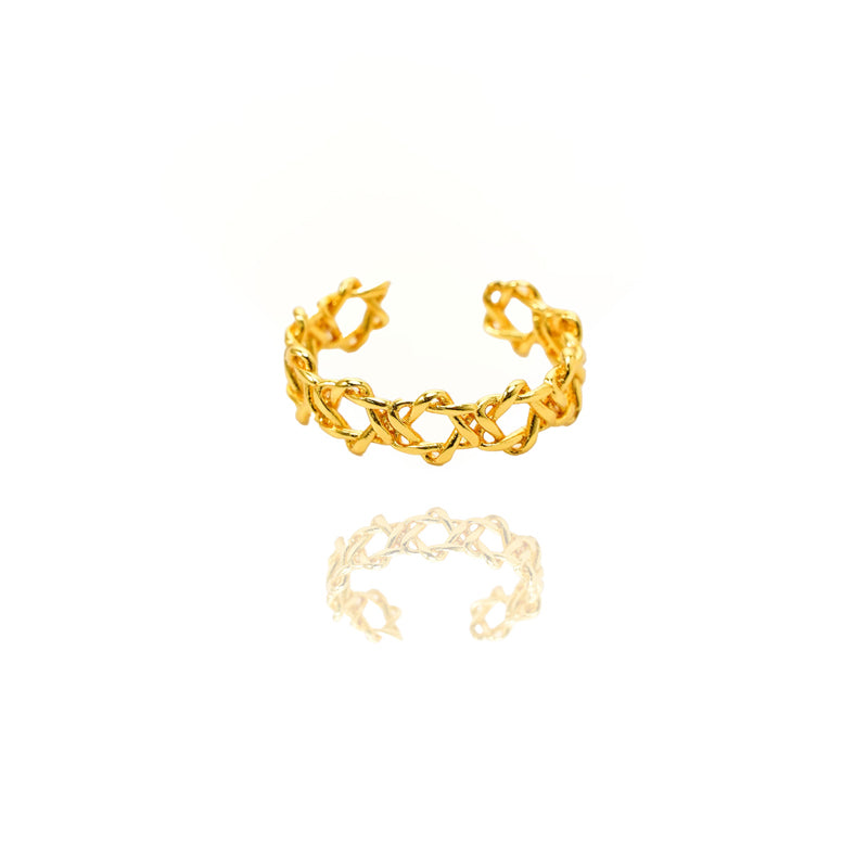 Gold ring with intricate design on a white background