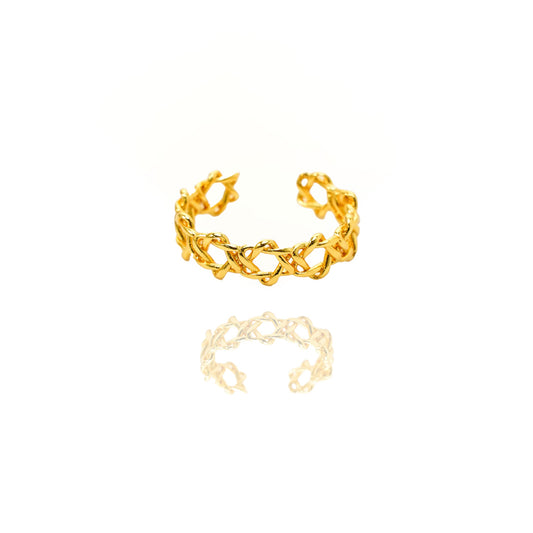 Gold ring with intricate design on a white background