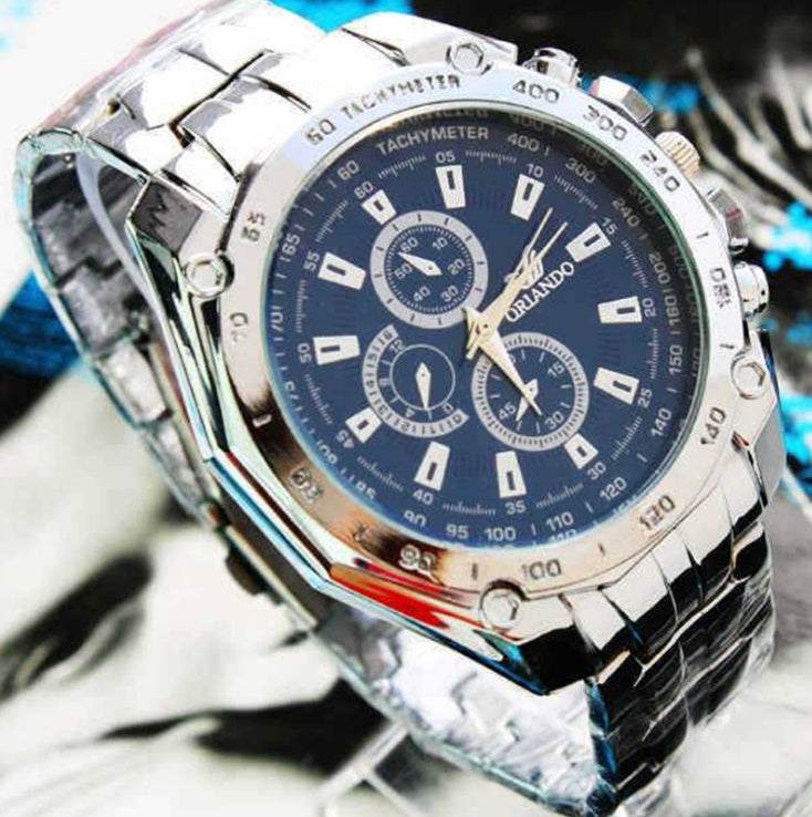 Silver wristwatch with a blue face on a blurred background