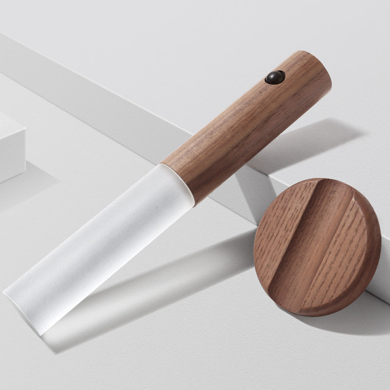Wooden spatula with a white blade on a light gray background