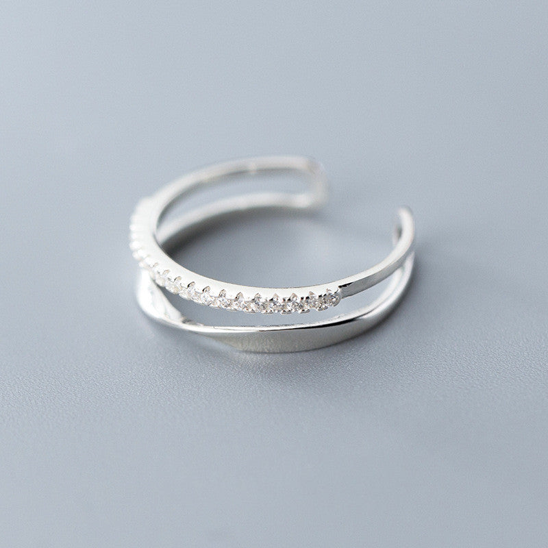 Silver ring with small stones on a light gray background