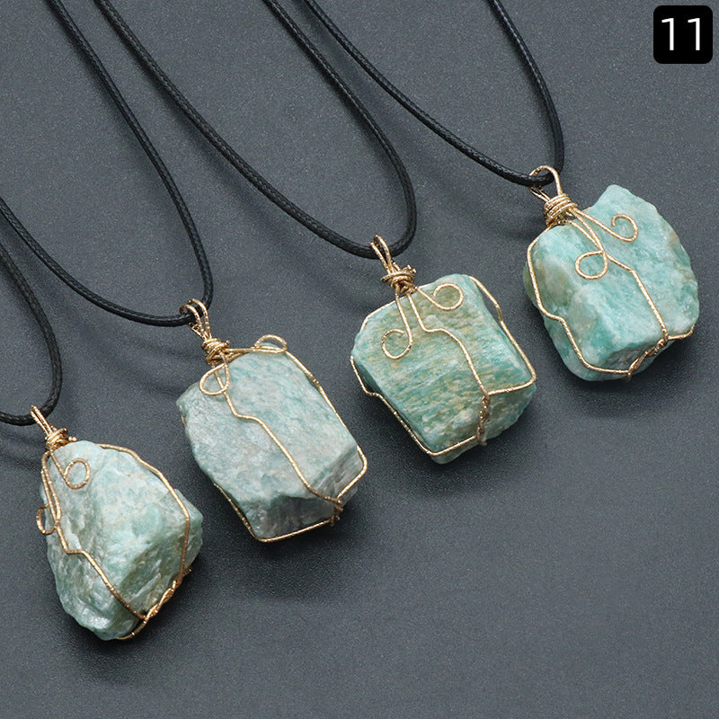Turquoise stone pendants with gold wire wrapping on black cords against a gray background