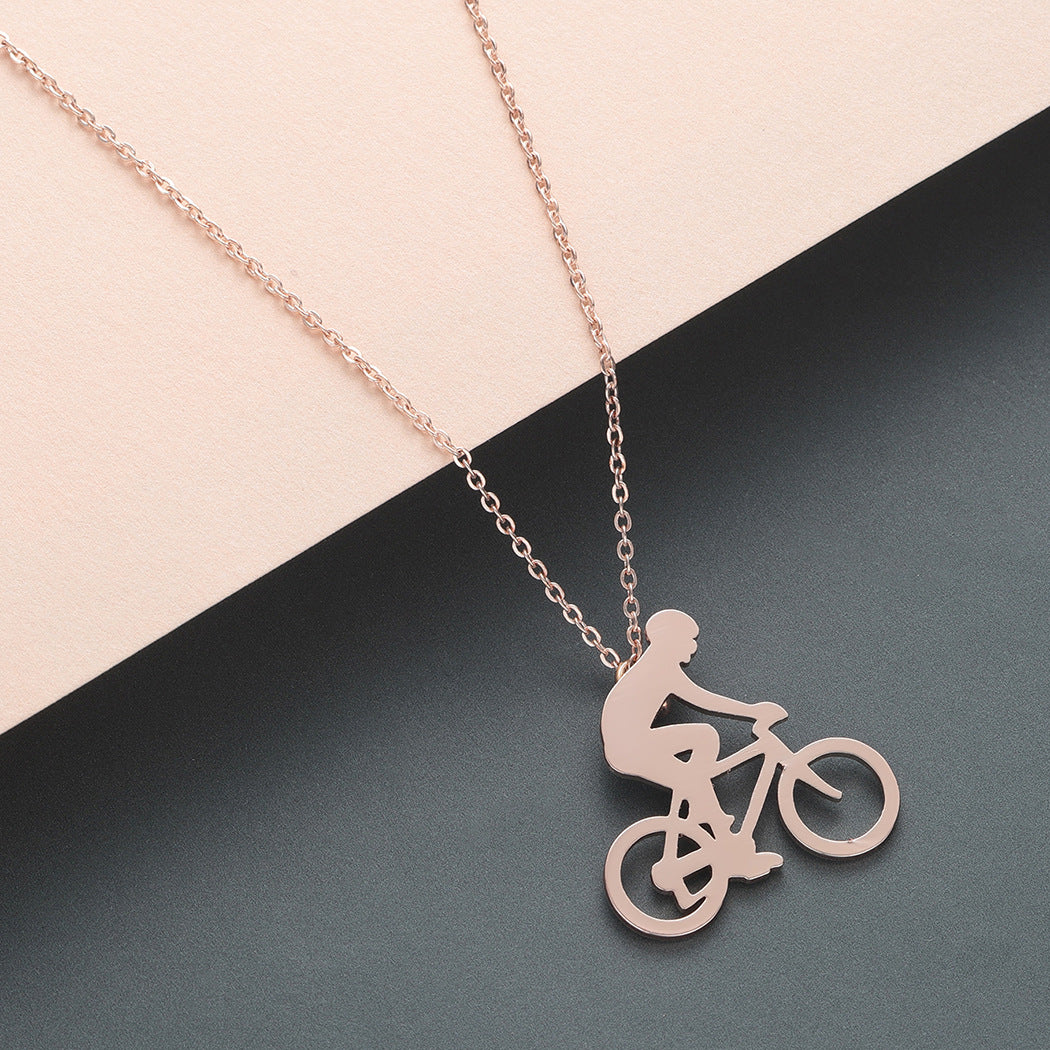 Rose gold necklace with a bicycle pendant on a two-tone background