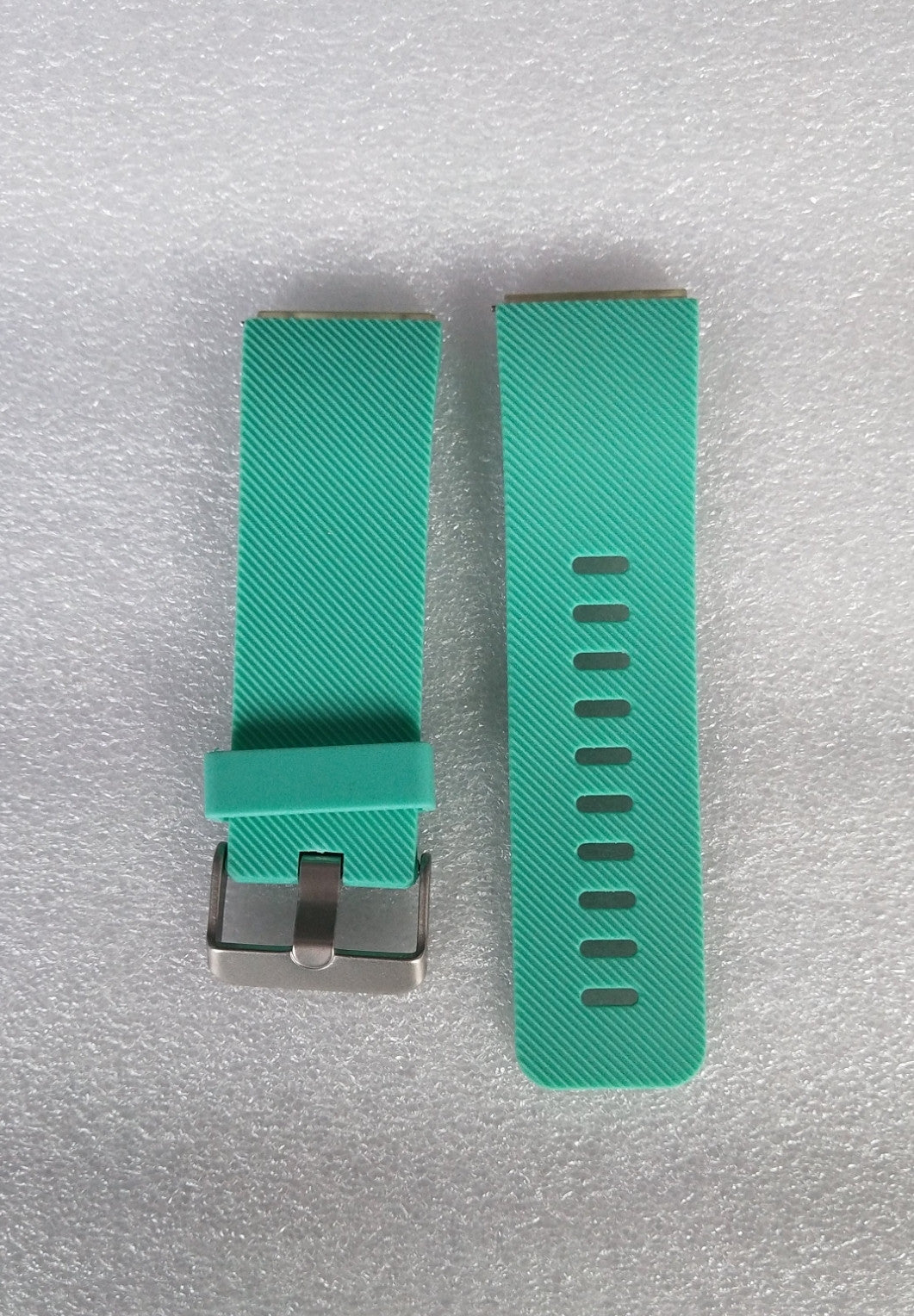 Teal watch strap with metal clasp on a light gray background