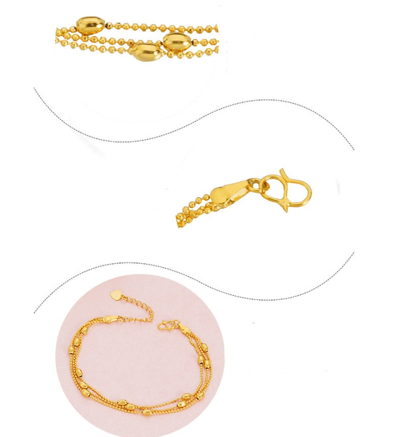Gold bracelet with clasp on a pink stand against a white background