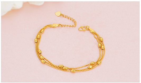 Gold bracelet on a pink background