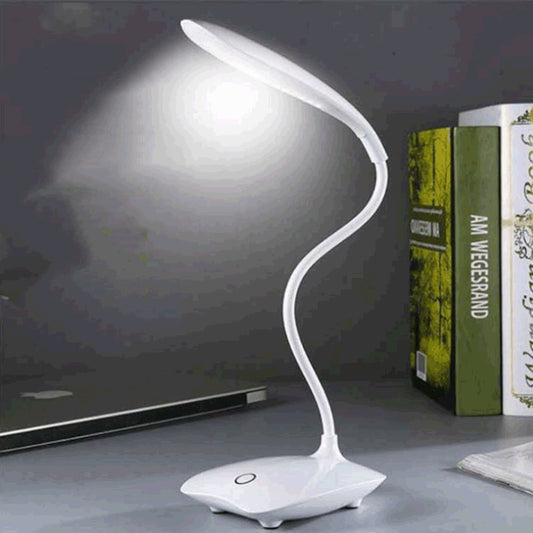 White LED desk lamp on a desk with books in the background