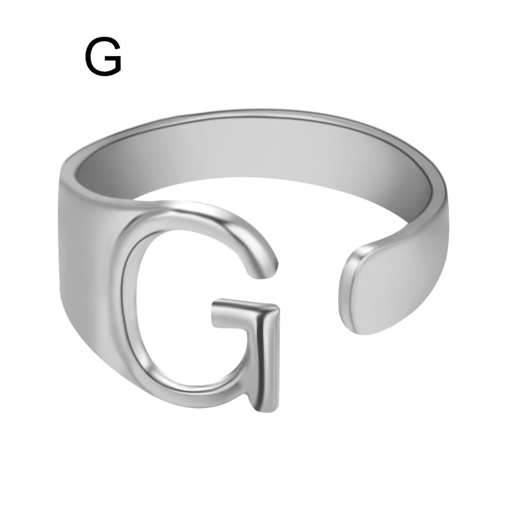 Silver ring with letter 'G' on a white background