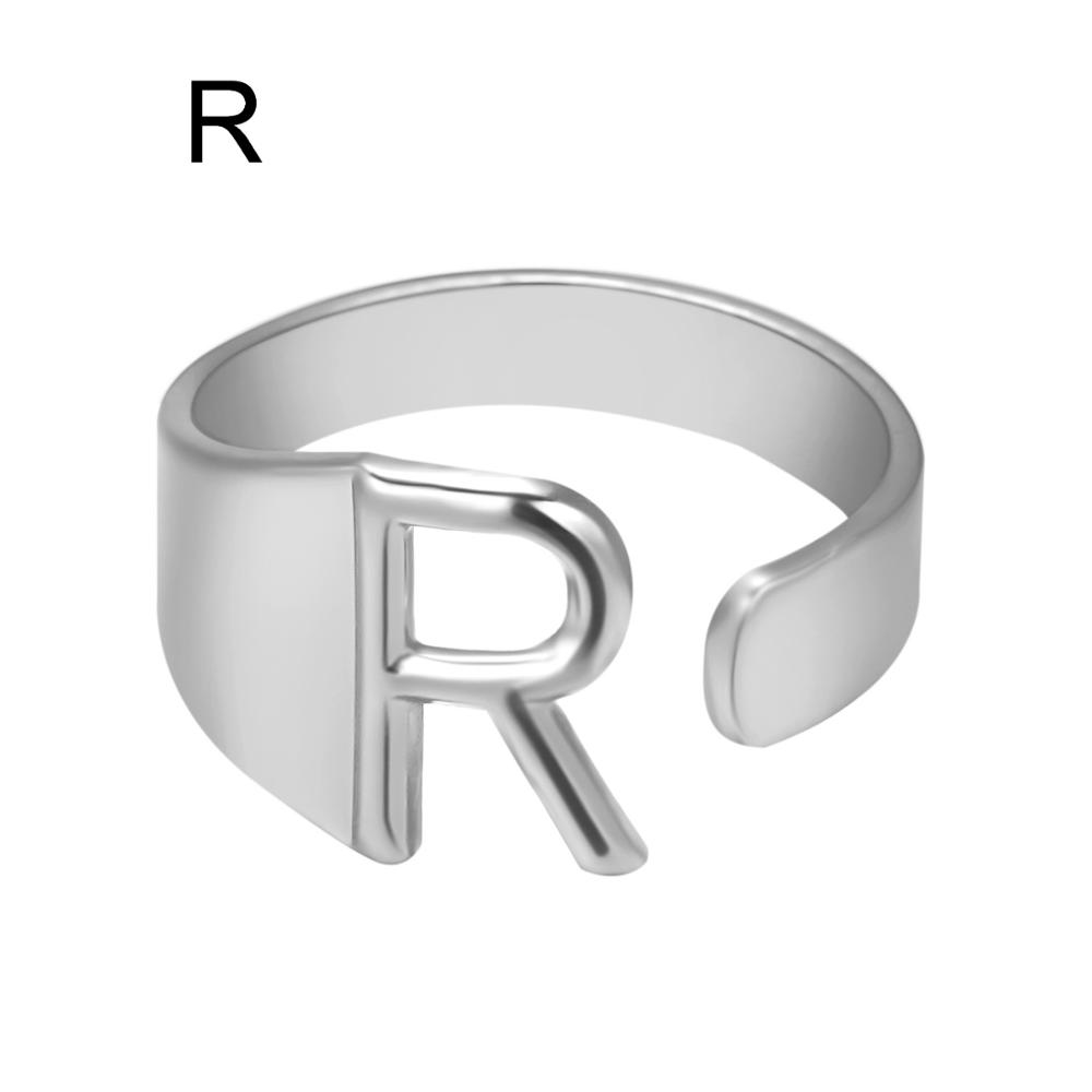 Silver ring with letter 'R' on a white background