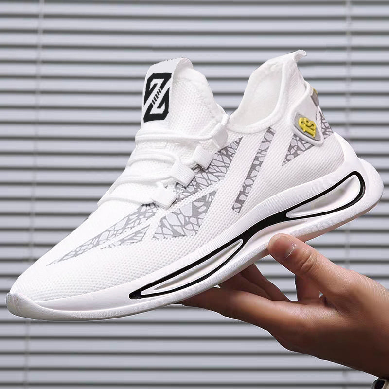 White sneaker with black accents held by a hand against a neutral background