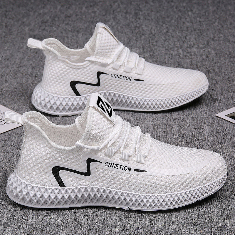 White sneakers with black branding on a gray surface