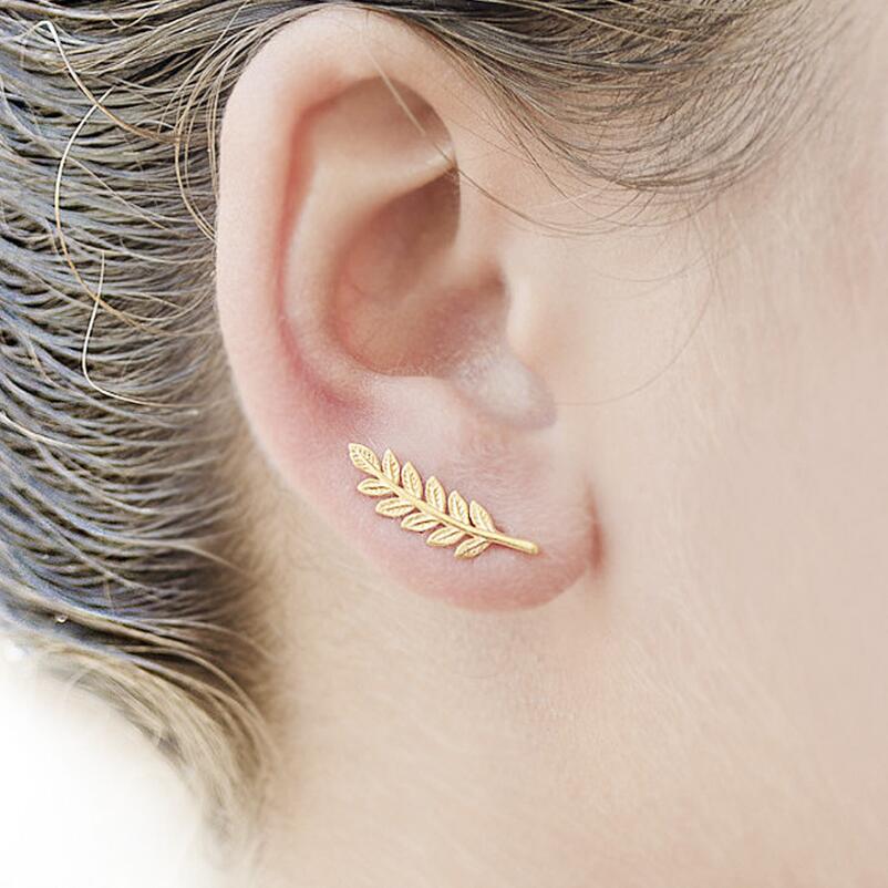 Gold leaf earring worn by a person with blonde hair.