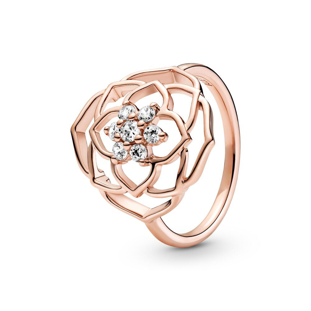 Rose gold ring with floral design and clear gemstones on a white background