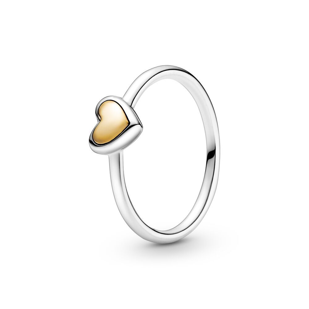Silver ring with a gold heart-shaped pendant on a white background