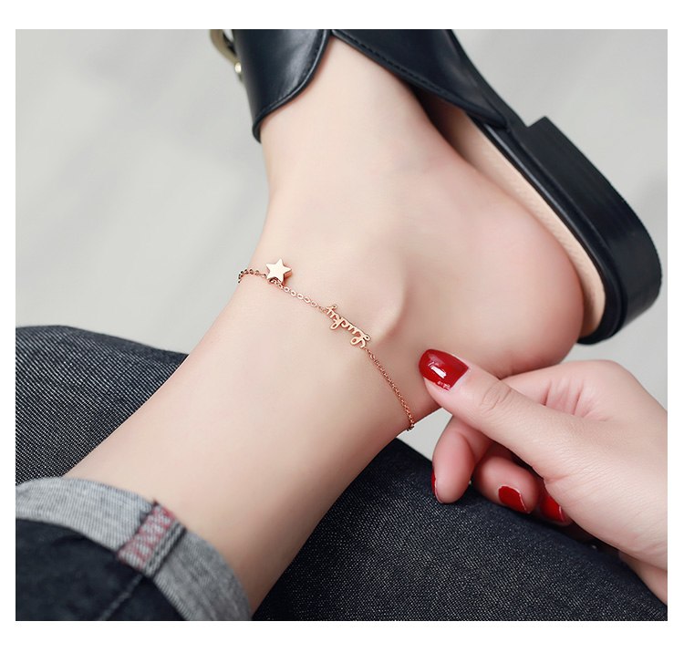 Person wearing a delicate bracelet on their wrist with a neutral background