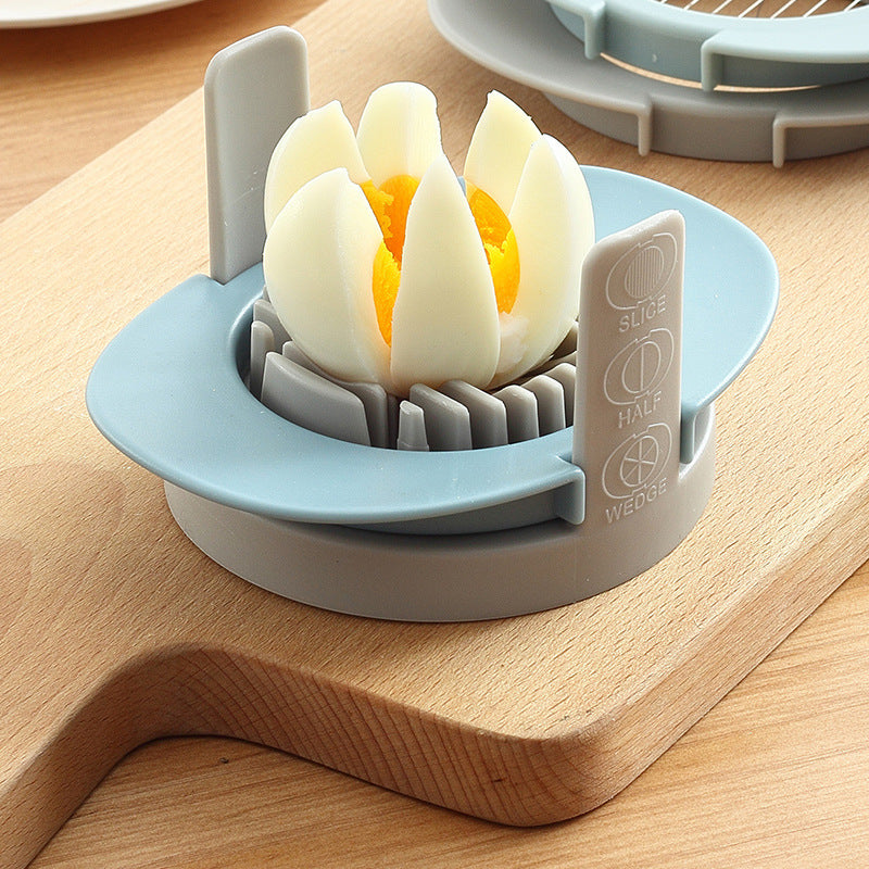 Egg slicer with a halved boiled egg on a wooden cutting board