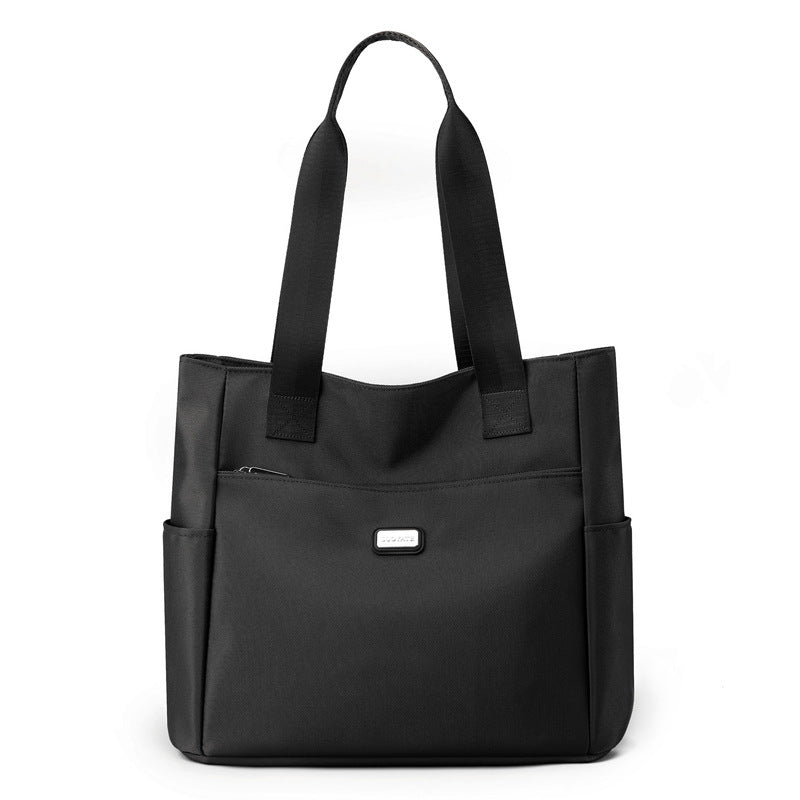 Black tote bag with a visible brand logo on a white background