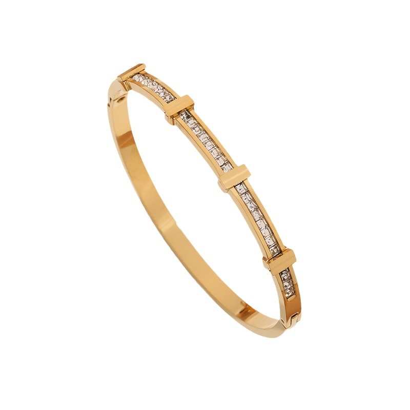 Gold bracelet with embedded diamonds on a white background