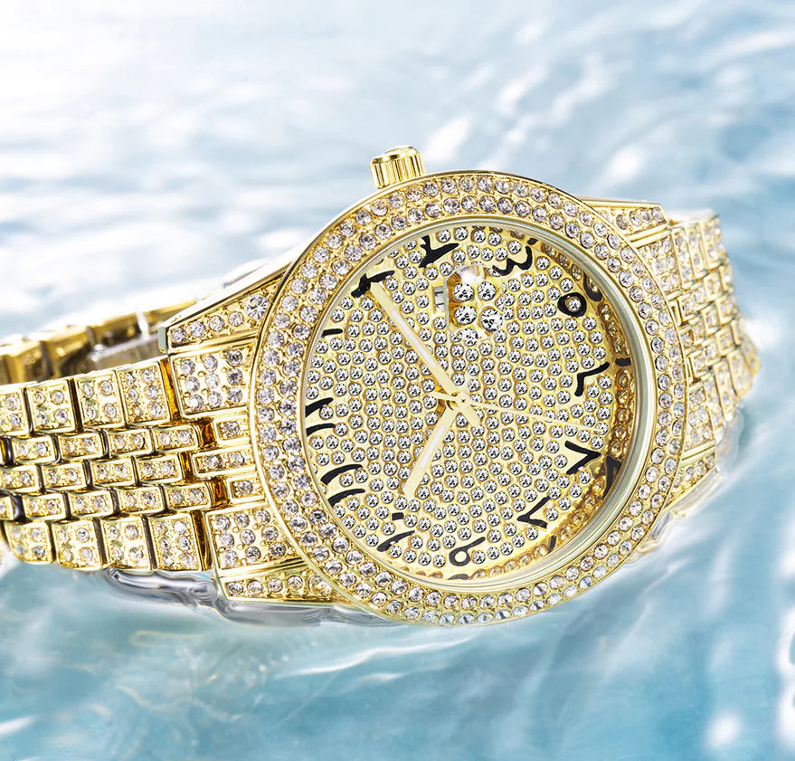 Gold watch with diamond-studded bezel on a water background