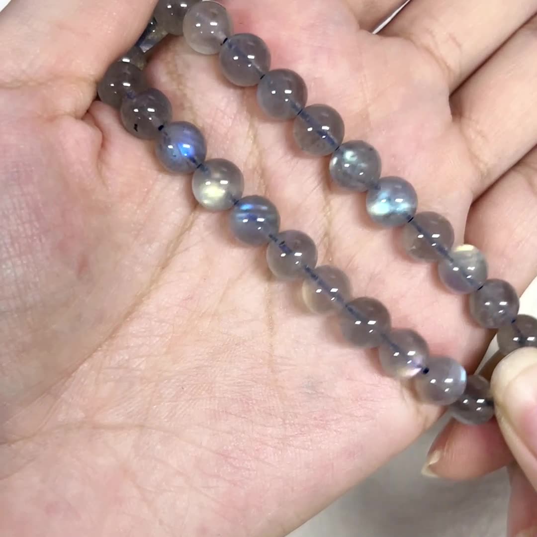 Hand holding a string of purple beads