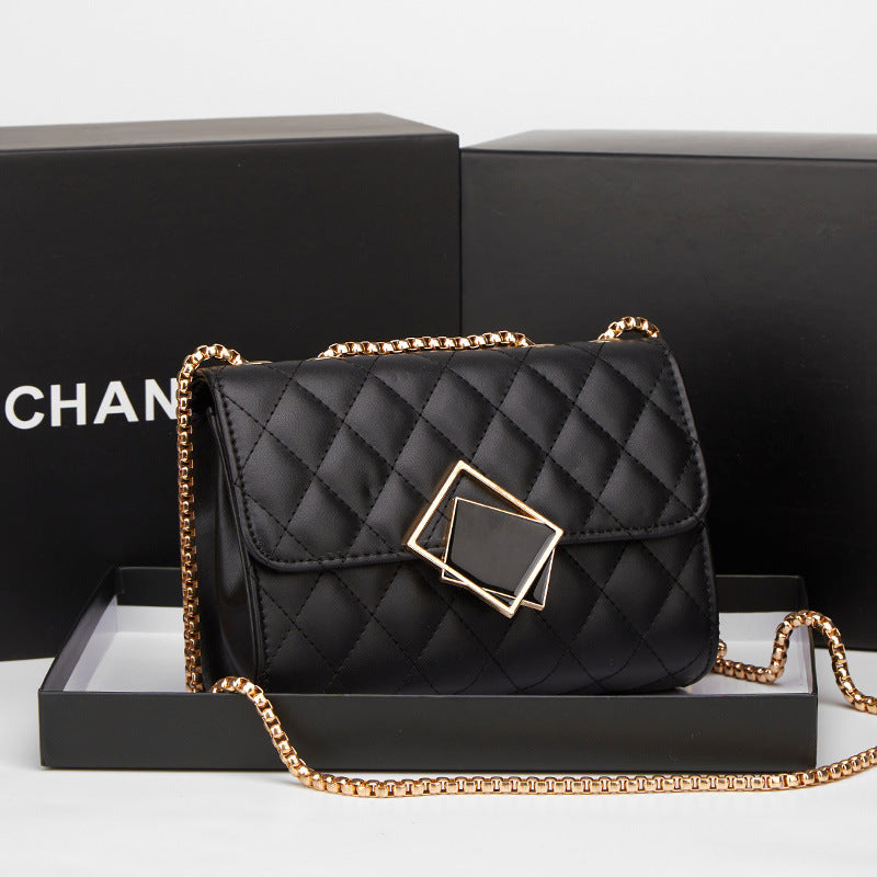 Black quilted handbag with gold chain strap on a white background
