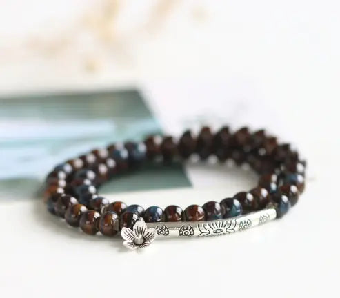 Beaded bracelet with a silver charm on a light background