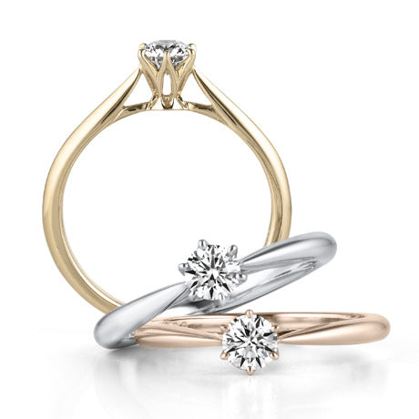 Three diamond rings in gold, silver, and rose gold on a white background