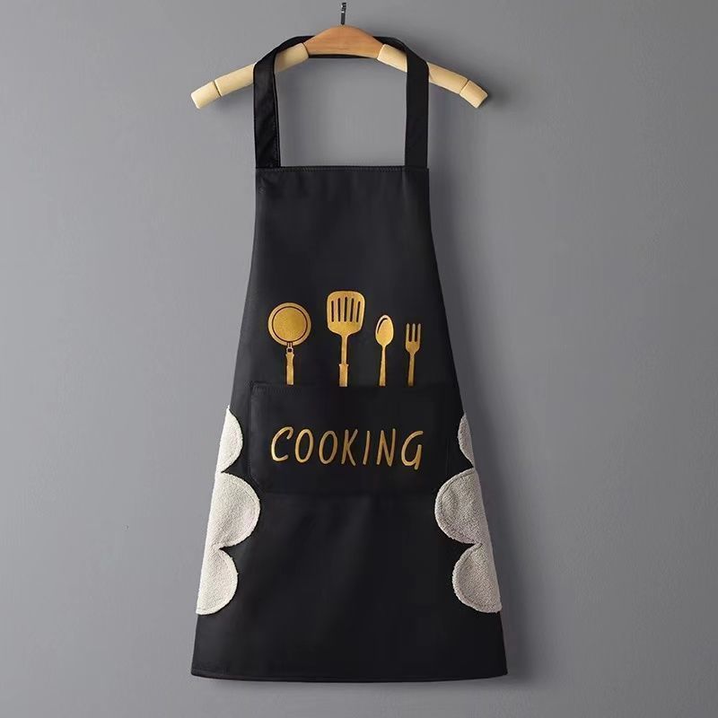 Black apron with gold cooking utensil icons and 'COOKING' text on a gray background