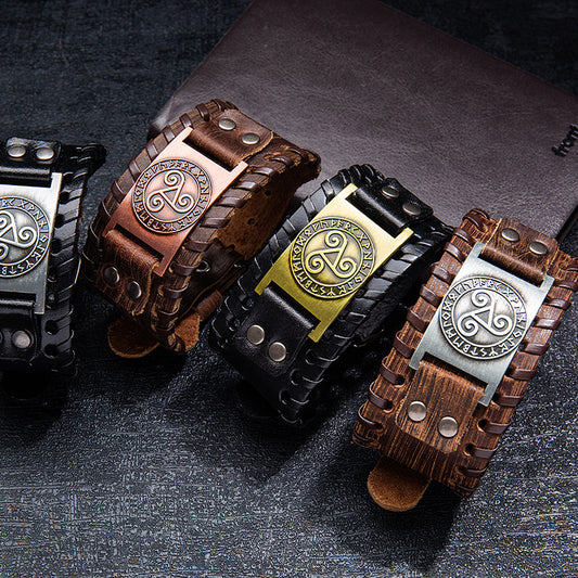 Four leather bracelets with metal buckles on a dark textured surface