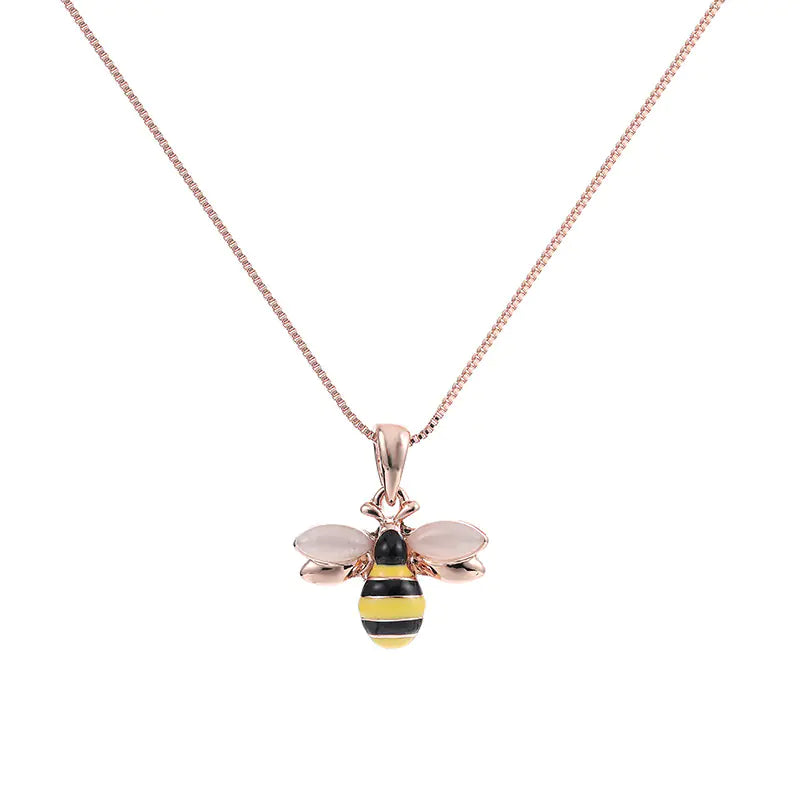 Rose gold bee pendant necklace on a white background