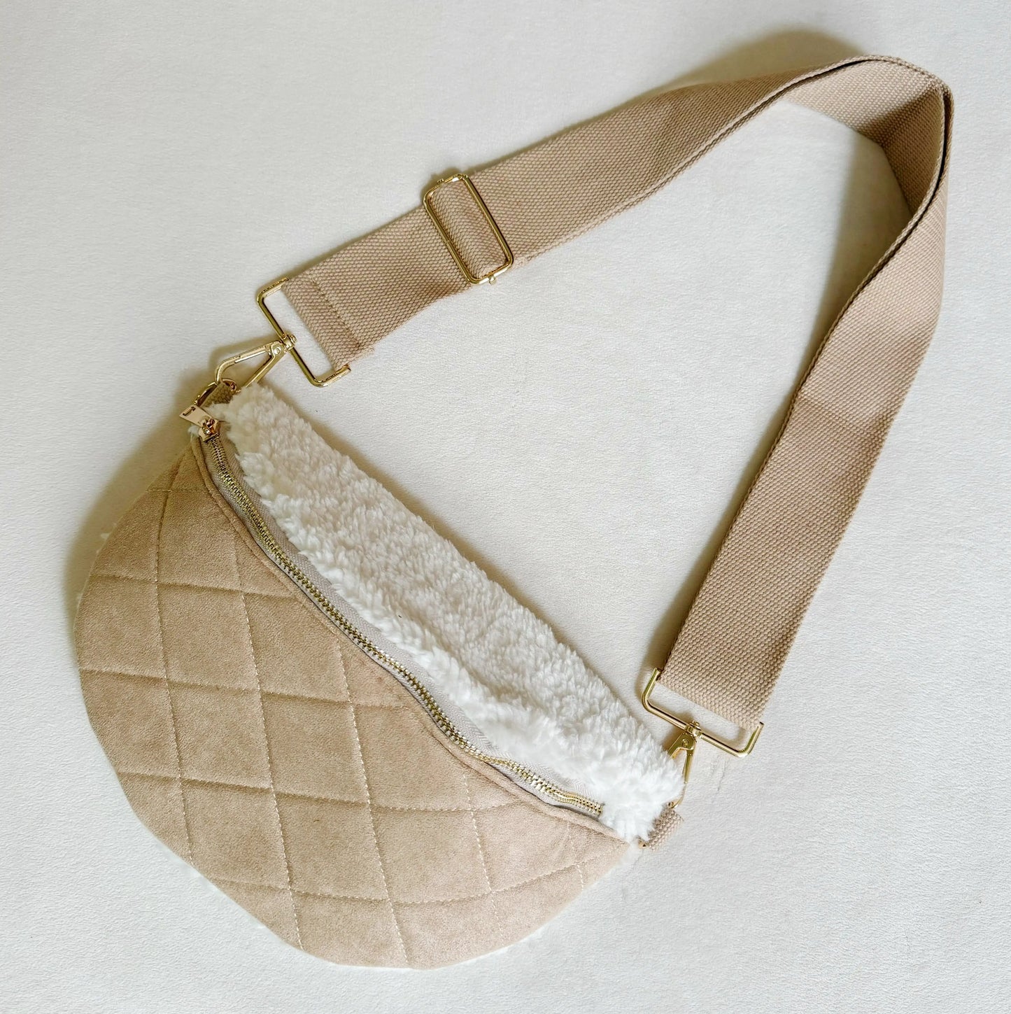 Beige quilted bag with white interior on a light gray background