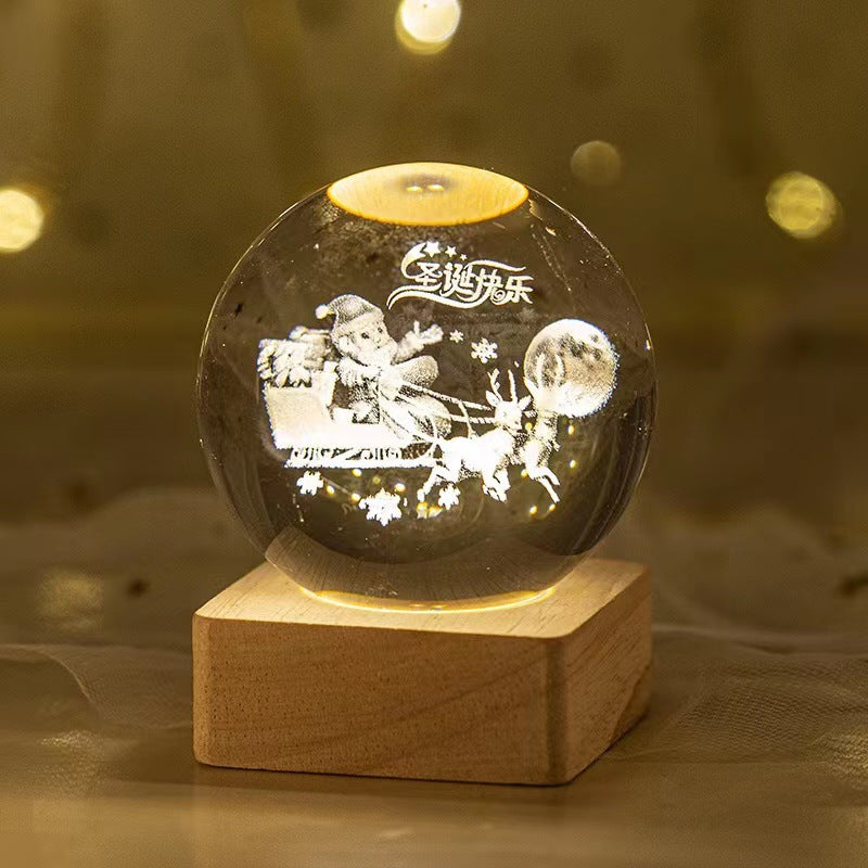 Decorative crystal ball with engraved design on a wooden base against a blurred background