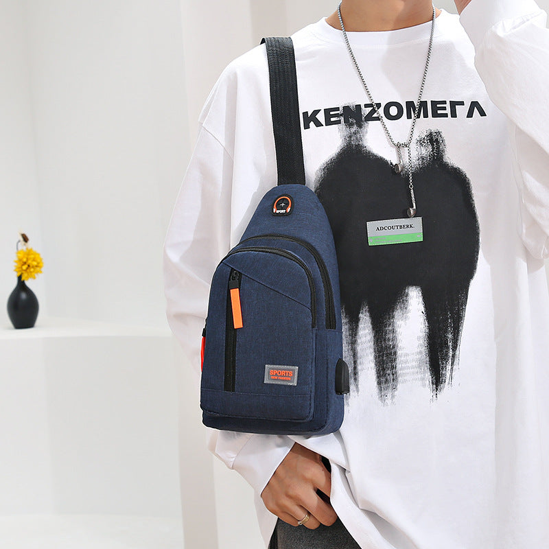 Person wearing a white shirt with black graphics holding a blue backpack.